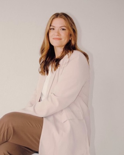 Mary, RN and owner of Wink Medical Spa, seated in a blush blazer