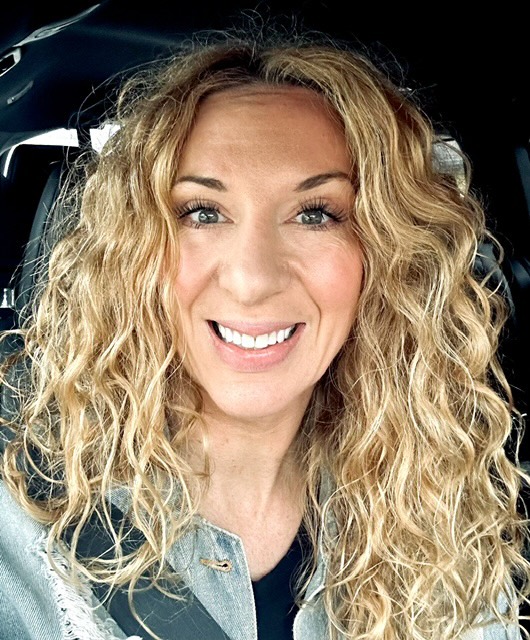 Michelle McAteer of Simply Beautiful Color with long curly blonde hair
