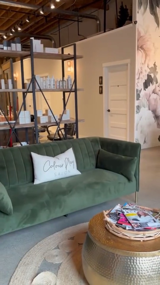 Client lounge with green velvet sofa, Colour Play pillow and brass side table