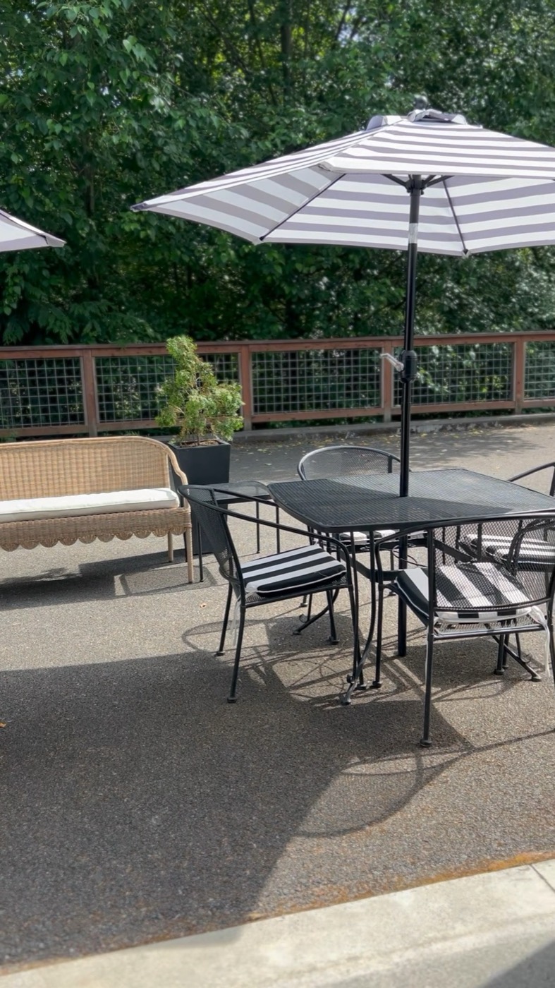 Colour Play Salon patio in Mill Creek with gray and white striped umbrellas, bistro sets and evergreen trees
