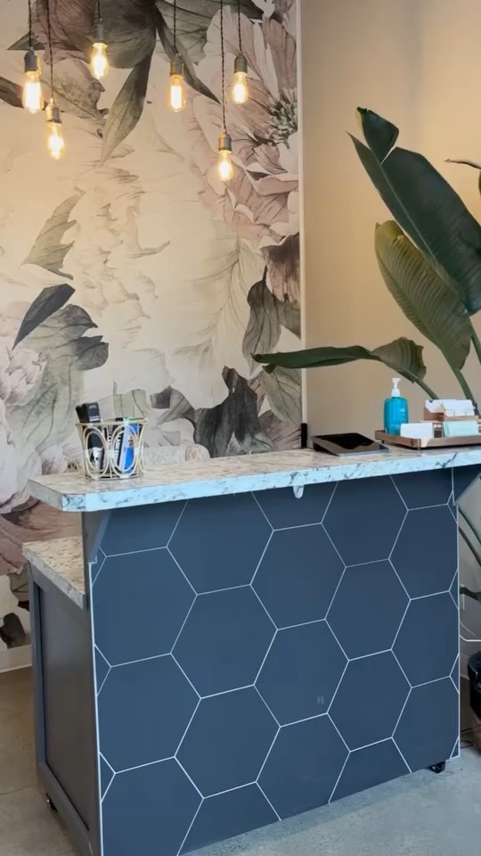 Colour Play reception with navy hexagon tile, botanical mural and brass pendant lights